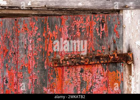 Rote Farbe an der Tür einer verlassenen Scheune. Stockfoto
