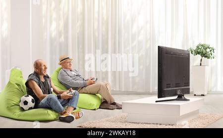 Vater und Sohn spielen Fußball-Videospiele vor einem fernseher zu Hause Stockfoto