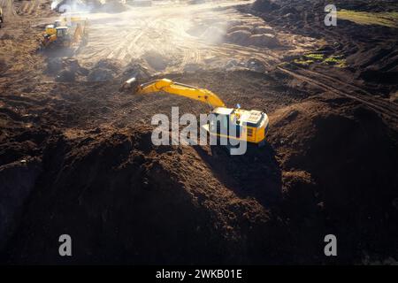 Gelber Raupenbagger arbeitet auf einer Baustelle. Stockfoto