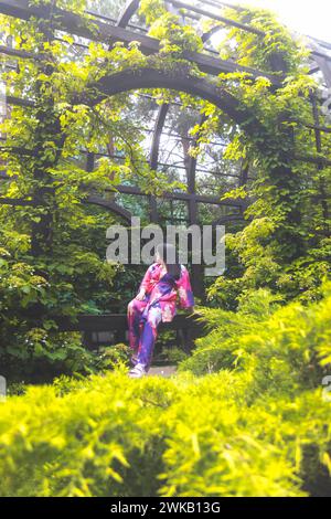 Mädchen in einem farbigen Kimono zwischen grünen Dickicht Stockfoto