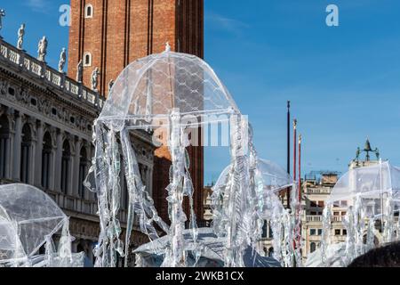 Venedig, Italien - 13. Februar 2024: Sonniger Tag am Karneval von Venedig mit wunderschönen Masken und weißen Regenschirmen, die über St. Marks Quadrat. Stockfoto