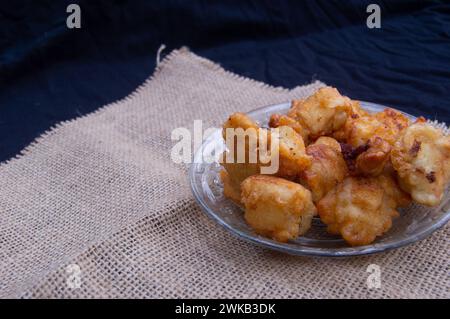 Tofu mit einer Schicht Mehl, das knusprig gebraten wird. Lebensmittelfotos mit schwarzem Hintergrund Stockfoto