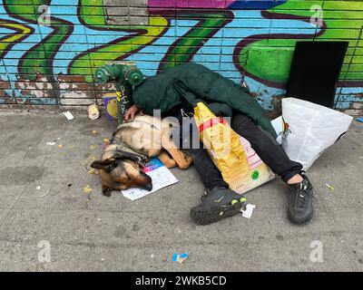 Der Mann und sein Hund schlafen auf dem Bürgersteig gleich neben der Canal Street in Chinatown in Manhattan, New York City. Stockfoto