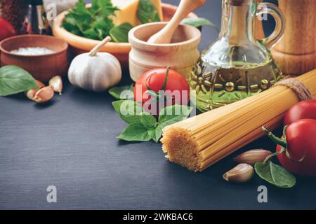 Zutaten zum Kochen von Pasta Spaghetti alla puttanesca - italienisches Pastagericht mit Tomaten, schwarzen Oliven, Kapern, Sardellen und Petersilie. Stockfoto