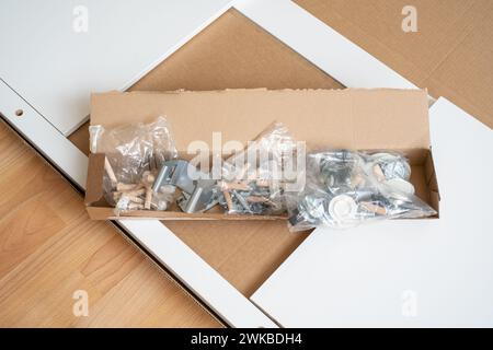 Ein Haufen von verpackten Teilen eines neuen Möbels, verschiedene Montagemöbel. Stockfoto