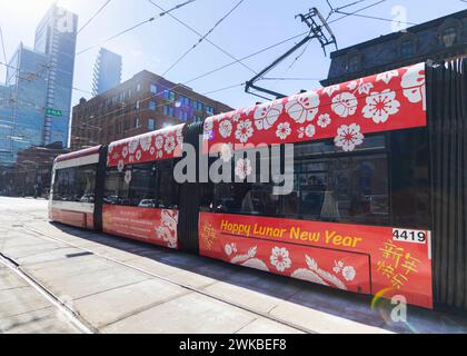 Toronto, Kanada. Februar 2024. Am 19. Februar 2024 ist eine Straßenbahn mit Lunar Silvester-Design auf einer Straße in Toronto, Kanada, zu sehen. Die Toronto Transit Commission (TTC) nahm an den Feierlichkeiten zum Neujahrsfest Teil, indem sie mehrere ihrer Straßenbahnen und Busse mit speziellen Designs umbaute. Quelle: Zou Zheng/Xinhua/Alamy Live News Stockfoto