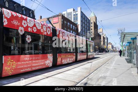 Toronto, Kanada. Februar 2024. Am 19. Februar 2024 ist eine Straßenbahn mit Lunar Silvester-Design auf einer Straße in Toronto, Kanada, zu sehen. Die Toronto Transit Commission (TTC) nahm an den Feierlichkeiten zum Neujahrsfest Teil, indem sie mehrere ihrer Straßenbahnen und Busse mit speziellen Designs umbaute. Quelle: Zou Zheng/Xinhua/Alamy Live News Stockfoto