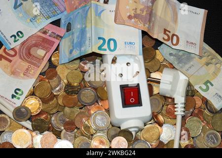 Steckdosenleiste und Geld, symbolisches Bild der Stromkosten Stockfoto