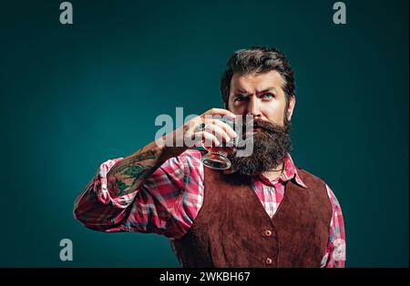 Whiskey. Modischer Mann in weißem Hemd und Strapshaltern. Konzept für Luxusgetränke. Stockfoto