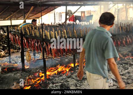 Eine geräucherte Fischproduktion, bei der Bonito-Thunfischfleisch in einer heimischen Industrie in Bitung, Nord-Sulawesi, Indonesien, verwendet wird. Der Beitrag indigener Wissens zur technologischen Innovation bietet laut dem Bericht des Zwischenstaatlichen Ausschusses für Klimaänderungen (IPCC) aus dem Jahr 2023 eine breite Palette von Optionen für das Management unter anderem der Ernährungssicherheit. Der im Volksmund als Cakalang Fufu bekannte geräucherte Thunfisch gilt als exotisches einheimisches Lebensmittel und könnte eine alternative Lösung für den Umgang mit den Auswirkungen des Klimawandels auf den Ozean werden. Stockfoto