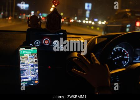 Nachtfahrten mit Routennavigation in einem Smartphone, das an einem Freisprechgerät befestigt ist Stockfoto