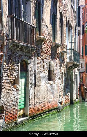 Außenwände eines alten Gebäudes in einem kleinen Kanal in Venedig, Italien, die reparaturbedürftig sind Stockfoto