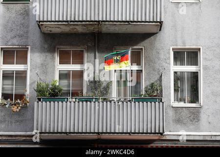 Eine deutsche Flagge mit einem Bundesadler flattert auf dem Balkon eines heruntergekommenen Wohnhauses, Berlin, 11. Oktober 2019 Stockfoto