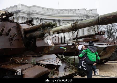 Kiew, Ukraine. Februar 2024. Eine Frau und ihr Kind sehen sich zerstörte russische Panzer in Zentral-Kiew an. Russische Truppen drangen am 24. Februar 2022 in ukrainisches Gebiet ein und begannen einen Konflikt, der Zerstörung und eine humanitäre Krise hervorgerufen hat. Quelle: SOPA Images Limited/Alamy Live News Stockfoto