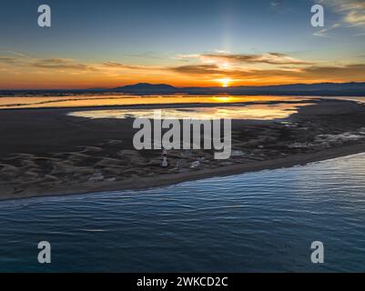 Aus der Vogelperspektive von Punta del Fangar und seinem Leuchtturm bei einem roten Winteruntergang im Ebro-Delta (Tarragona, Katalonien, Spanien) Stockfoto