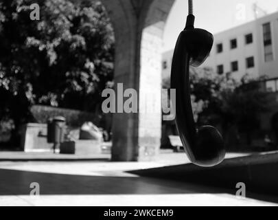 Münztelefon hängt am Kabel in einem einsamen Teil der Innenstadt von Guadalajara. Stockfoto