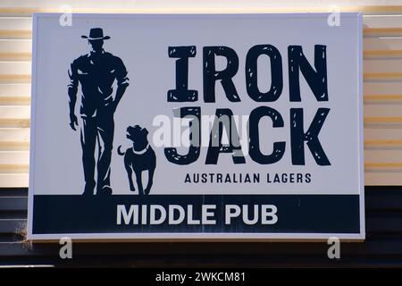 Mann mit Hund, Plakatwand für Iron Jack Australian Lager an der Wand des Middle Pub in Northampton, Western Australia Stockfoto