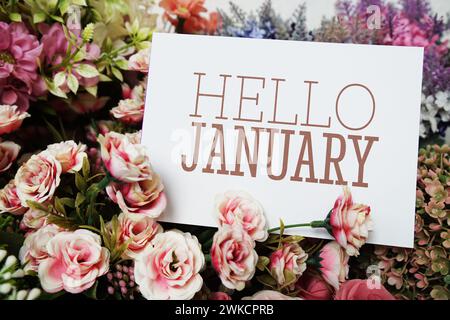 Hallo Januar Textnachricht auf Papierkarte mit wunderschöner Blumendekoration Stockfoto