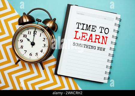 Es ist Zeit, etwas Neues auf Notizblock und Wecker zu lernen Stockfoto