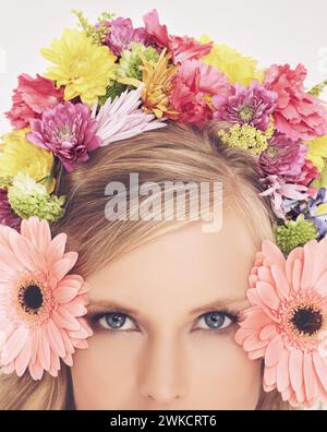 Frau, Porträt und Blumen auf der Krone für Schönheit, Selbstvertrauen und Wohlbefinden mit Frühlingsästhetik und Blumenkunst. Modell, Gesicht und Kosmetik mit Stockfoto