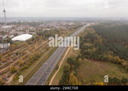 Drohnenaufnahmen von mehrspurigen Autobahnen in der Nähe einer Stadt während des bewölkten Herbsttags Stockfoto
