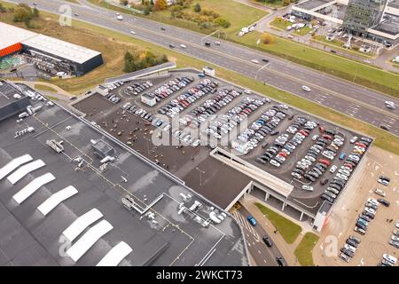 Drohnenfotografie eines fast vollen Parkplatzes in der Nähe eines Einkaufszentrums während des bewölkten Herbsttags Stockfoto