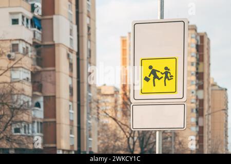 Kinder, die sich in der Nähe des Schulverkehrs bewegen, weisen eine Warnung auf und raten den Verkehrsteilnehmern, besonders langsam und selektiv zu fahren Stockfoto