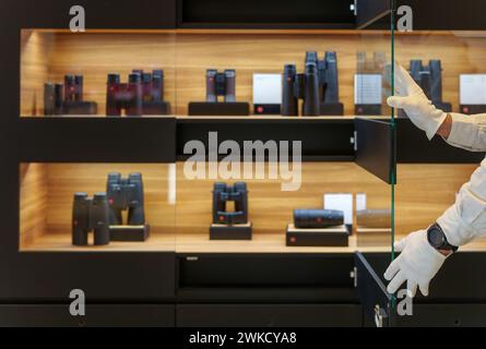 Wetzlar, Deutschland. Februar 2024. Eine Vitrine mit Fernglas wird im Leica Store geöffnet. Die deutsche Leica Camera AG hat ihren Sitz in Wetzlar. Das Unternehmen der optischen Industrie ist unter anderem für seine hochwertigen Kameras, Objektive und Ferngläser bekannt. Darlegung: Andreas Arnold/dpa/Alamy Live News Stockfoto