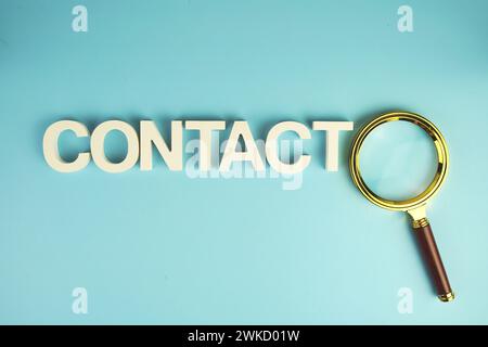 Setzen Sie Buchstaben mit Lupe auf blauem Hintergrund in Kontakt Stockfoto