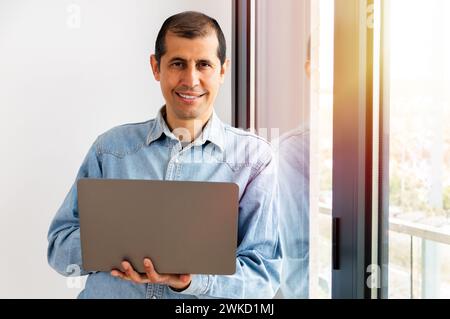 Porträt eines jungen Geschäftsmannes, der in seinem Heimbüro Alaptop verwendet Stockfoto