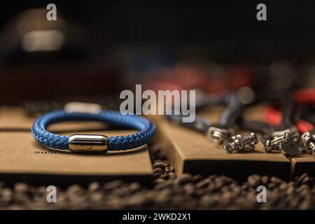 Ein blaues Armband mit einem Ankersymbol in einem Geschäft. Es gibt noch andere Souvenirs und Accessoires. Kaffeebohnen als Dekoration Stockfoto