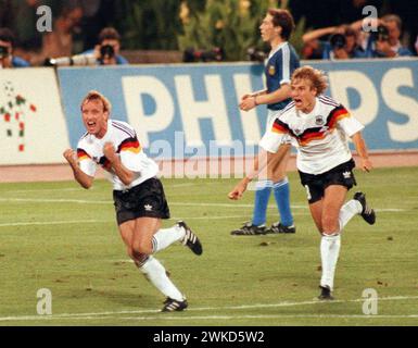 FILED - 08 Juli 1990, Italien, Rom: Der ehemalige deutsche Nationalspieler Andreas Brehme (l) und Jürgen Klinsmann laufen über das Spielfeld des Olympiastadions in Rom, um zu feiern, nachdem Brehme einen Elfmeter für Deutschland erzielte 1-0 Vorsprung. Die deutsche Mannschaft besiegte Argentinien im Finale der Weltmeisterschaft mit 1:0. Fußball-Weltmeister Andreas Brehme starb im Alter von 63 Jahren, wie seine Familie am Dienstag vor der Deutschen Presseagentur bestätigte. (Zu dpa: 'Fußball-Weltmeister Andreas Brehme starb') Foto: Frank Kleefeldt/dpa Stockfoto