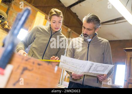 Zimmerleute planen und arbeiten zusammen Stockfoto