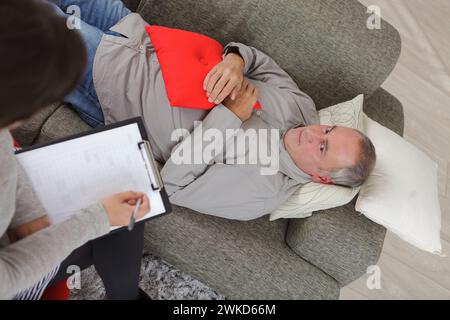 Mann sitzt auf dem Sofa und fühlt sich hoffnungslos depressiv Stockfoto