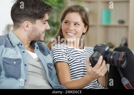 Porträt eines glücklichen lächelnden, liebevollen jungen Paares, das eine Kamera hält Stockfoto