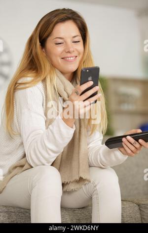 Glückliche Frau, die auf einer Couch sitzt Stockfoto