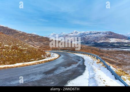 Applecross Halbinsel Schottland Bealach na Bà mit Blick auf die Straße zurück in Richtung Loch Kishorn und verschneite Berge im Winter Stockfoto