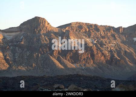 El Teide Volcanic National Park auf Teneriffa, Spanien. Orangefarbene Klippen und Berge im Sonnenuntergang. Trockene marsartige Landschaft Stockfoto
