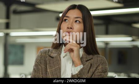 Asiatisches Mädchen im Büro koreanische Geschäftsfrau Dame chinesische Geschäftsfrau japanische Managerin Arbeiter Studentin drinnen verwirrt nachdenklich nachdenklich Stockfoto