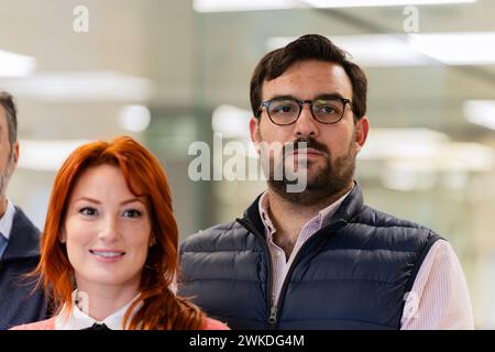 Eine vielfältige Gruppe von Fachleuten, die sich selbstbewusst in einem gut beleuchteten, modernen Büroumfeld ausgeben. Stockfoto