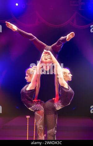 Weißrussland, Gomel, 1. April 2018. Gomel State Circus. Akrobatische Mädchen spielen einen Trick unter blauen Bühnenlichtern. Stockfoto