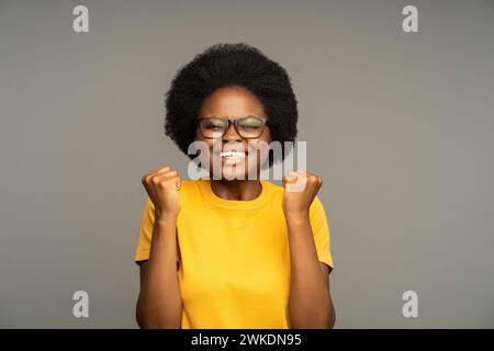 Eine überfröhliche afroamerikanische Frau, die glücklich ist mit guten Nachrichten, Zielerreichung, Erfolg, Gewinn. Stockfoto