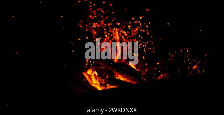 Feuer und Funken auf schwarzem Hintergrund. Lagerfeuer mit Funken Stockfoto