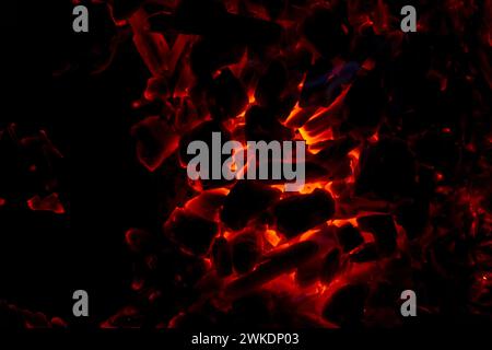 Glühende rote Kohle in der Nacht. Brennendes Feuer Stockfoto