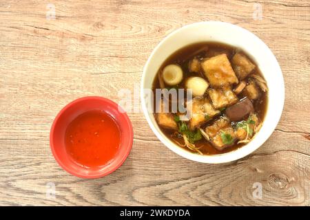 Geschmorter Fischschlamm mit Bambussprossen, garniert gekochtes Ei in roter Soße Suppe auf einer Schüssel Stockfoto