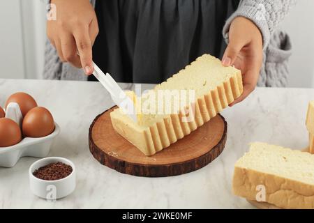 Butter Margarin auf Roti Bakar Bandung Brot verteilen, weibliche Hand Brot Toast machen Stockfoto