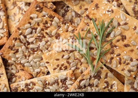 Rosmarin auf Müslicrackern mit Flachs, Sonnenblumen und Sesamsamen, Blick von oben Stockfoto