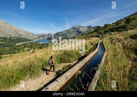 Escursionista andando junto a la Canal de transvase del Gorg Blau - Cúber, Escorca, Paraje natural de la Serra de Tramuntana, Mallorca, balearische Inseln, Spanien. Stockfoto