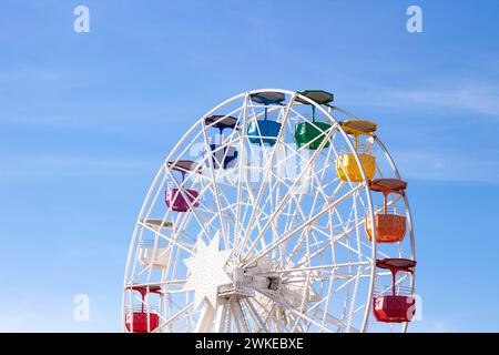 Riesenrad mit mehrfarbigen Fahrerhäusern auf blauem Himmel Stockfoto