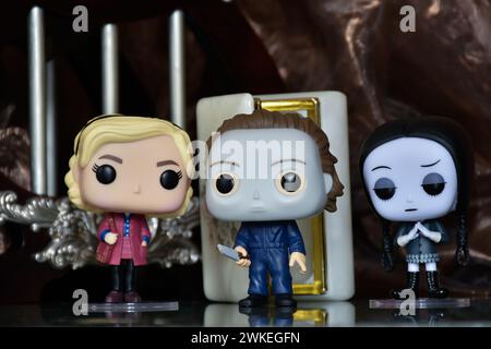 Funko Pop Actionfiguren von Sabrina Spellman, Serienmörder Michael Myers von Halloween und Wednesday Addams. Säulen, Reflektionsboden, weiße Tür. Stockfoto